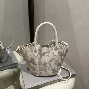 Elegant off-white floral embroidery bucket bag with wavy edges and shoulder strap