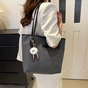 Grey woven tote bag with shoulder straps and cute plush monster charm detail