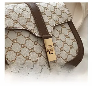 Close-up of golden rectangular metal buckle on saddle bag with brown bear print pattern