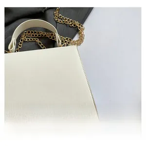 Detailed close-up of white PVC textured crossbody bag with golden hardware and chain strap
