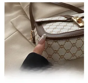 Detail of high-quality stitching on printed canvas saddle bag with golden hardware