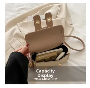 Detail view of beige crossbody bag interior holding a smartphone and wallet