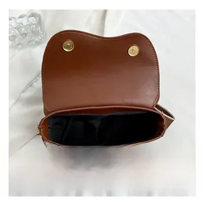 Interior view of brown vintage saddle bag showing black lining and dual magnetic closure