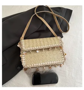 Detail of woven straw bag with lace trim, seashell charms and size comparison