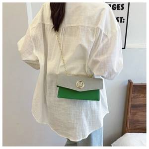 Détail du sac bandoulière vert et argent avec boucle dorée M et bandoulière chaîne