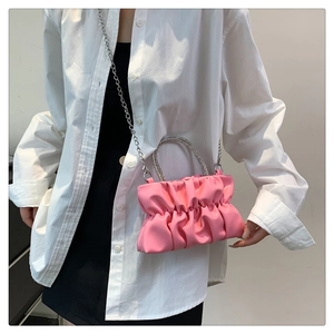 Detail of pink ruched cloud bag with sparkling rhinestone handle and silver chain strap