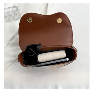 Internal view of the brown leather saddle bag showing sunglasses and a wallet
