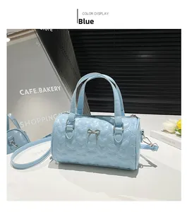 Detalle del bolso Boston azul claro con acolchado de corazones, lazo de metal y cremallera