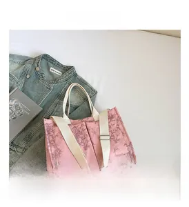 Pink tote bag detail with dark grey bamboo leaf print and functional front pockets