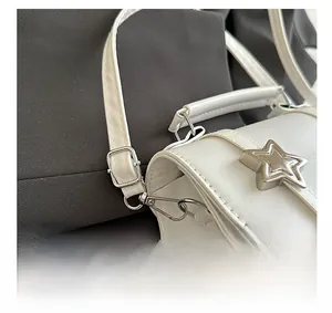 Macro view of silver hardware detailing with star ornament on white leather handbag