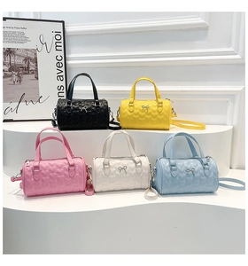 Vista de detalle de bolsos cilíndricos acolchados en varios colores con lazos plateados