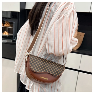 Brown half-moon saddle bag with vintage geometric patterns shown on a model