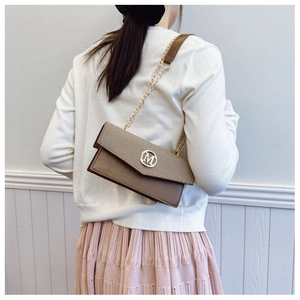 Sac bandoulière marron avec logo M métallique porté à l'épaule sur un mannequin