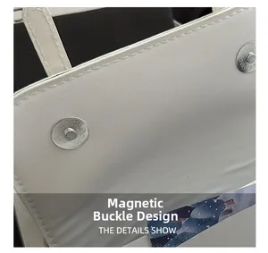 Detailed macro view of the silver magnetic snap closure on a white leather handbag