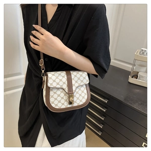 Detailed side view of a vintage monogram saddle bag with golden clasp on female model