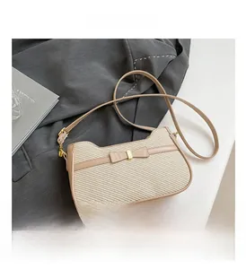 Close-up of woven texture handbag with a bow detail and adjustable leather strap