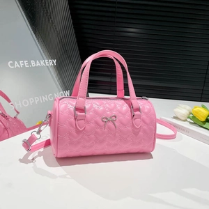 Pink heart quilted barrel bag with silver bow accent and adjustable shoulder strap