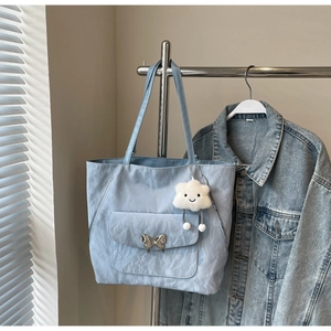 Detail of light blue crinkled tote bag with metal butterfly buckle and cloud charm