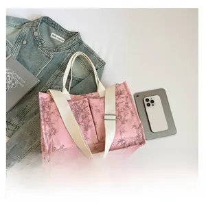 Pink floral tote bag with bamboo leaf pattern and adjustable shoulder strap detail