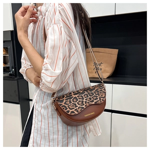 Detail of vintage saddle bag with leopard print flap and brown faux leather texture