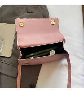 Interior view of pink shell bag with scalloped edges and gold magnetic buckle closure