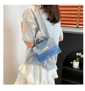 Close-up of blue translucent chain bag with geometric texture and sparkling finish