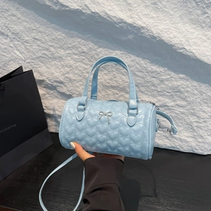 Light blue heart quilted cylinder handbag with silver bow detail and shoulder strap