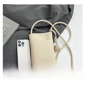 Beigefarbene Beuteltasche aus Leder mit Kieselmaserung und Smartphone zum Größenvergleich