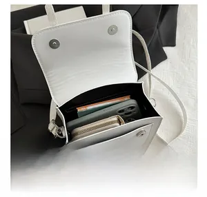 Internal view showing the storage capacity and compartments of the white satchel bag