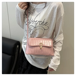 Vue latérale du sac porté épaule rose motif crocodile avec boucle fer à cheval dorée