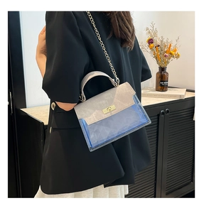 Fashionable crossbody bag with blue translucent quilted texture and grey suede flap cover