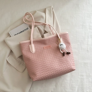 Pink woven tote bag with shoulder strap and white plush pendant for casual daily use