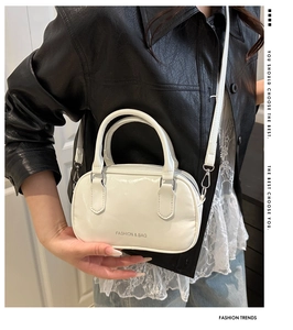 Close-up of white mini Boston bag with silver hardware and detachable crossbody strap