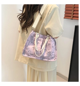 Detail of purple tote bag with bamboo leaf pattern shown in a side shoulder carry view