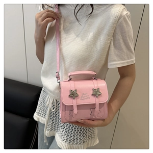 Detail of pink PU leather crossbody bag with silver stars and embossed fashion text