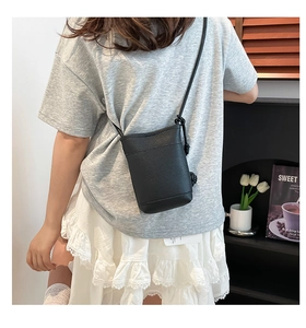 Rückansicht eines Models mit einer schwarzen Mini-Handytasche aus Leder mit Litschimuster