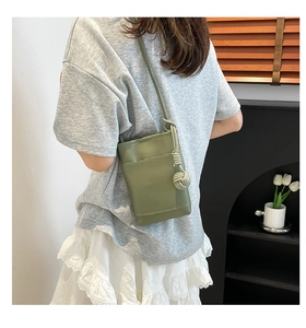 Nahaufnahme der matcha-grünen Handytasche mit Litschi-Maserung und Knotendetail