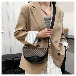 Detail of saddle bag featuring geometric dot flap and striped fabric shoulder strap