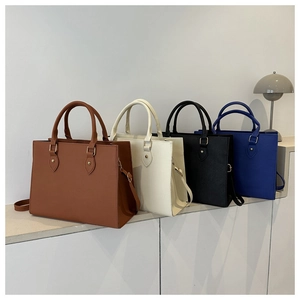 Detailed view of four business tote bags in brown, beige, black, and royal blue leather