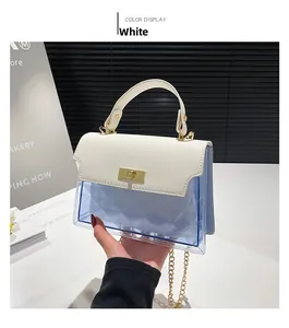 Detail of white leather flap with gold twist lock and clear blue PVC body on small square bag