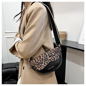 Detail of saddle bag with leopard print flap and wide striped fabric shoulder strap