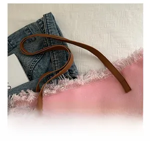 Detailansicht der rosa Segeltuchtasche mit Fransenkante und braunem Lederriemen