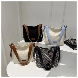 Détail de sacs seaux en toile de différentes couleurs sur un escalier géométrique