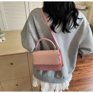 Pink crossbody bag featuring woven texture flap and wavy edge design on a model back view