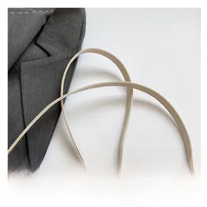Detail shot of the comfortable beige PU leather strap with precise stitching on a crossbody bag