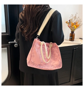 Pink tote bag with bamboo leaf pattern and wide shoulder strap shown in a lifestyle setting