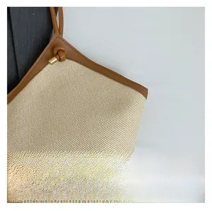 Close-up of woven fabric texture with brown leather handles on a large tote bag