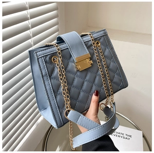 Détail du sac en similicuir matelassé bleu avec chaîne en or et fermoir doré