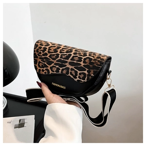 Detail of leopard print flap saddle bag with wide shoulder strap and gold logo