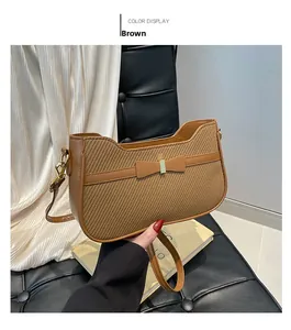 Detailed view of brown woven handbag with leather bow and golden metal buckle
